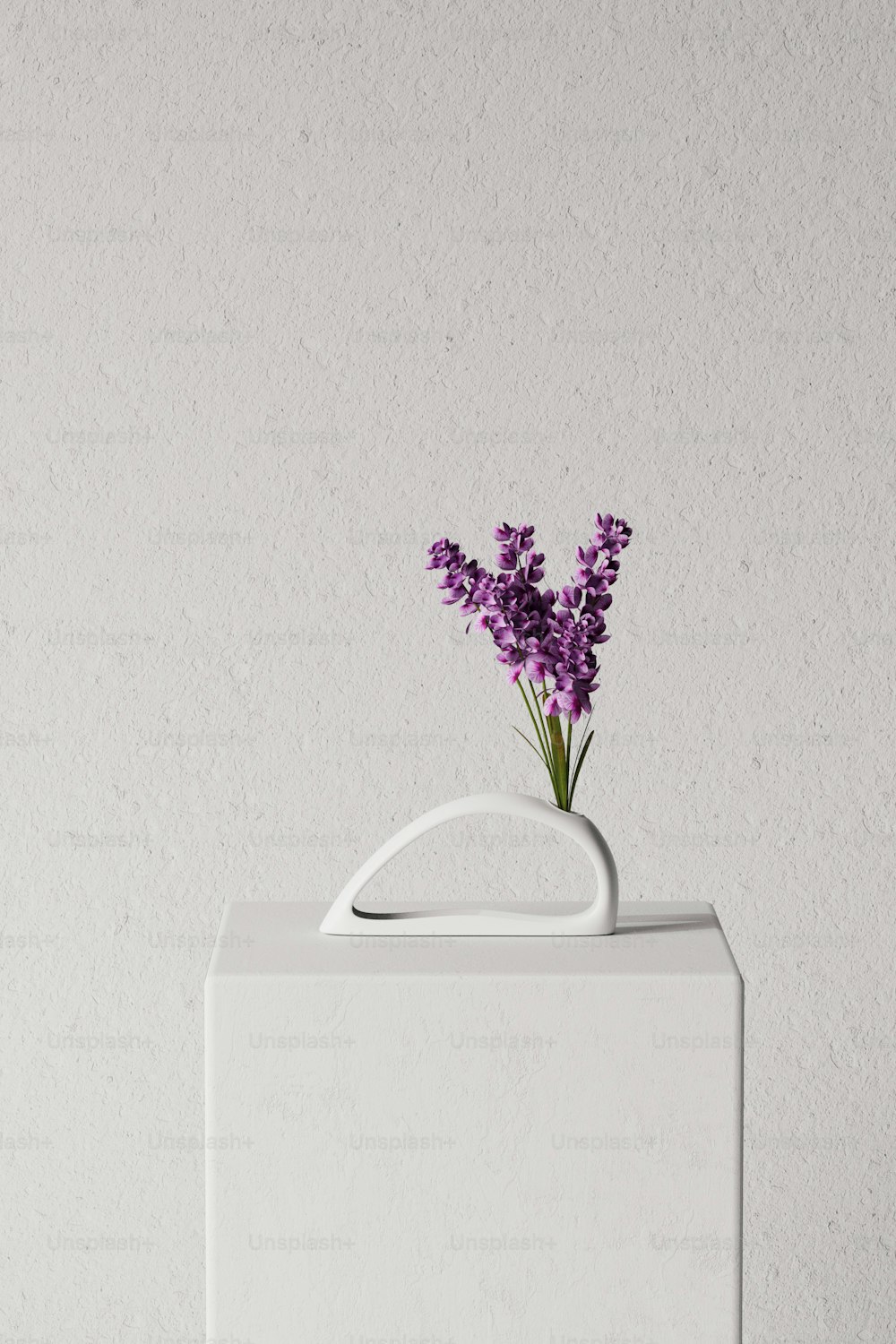 eine weiße Vase mit lila Blumen darin