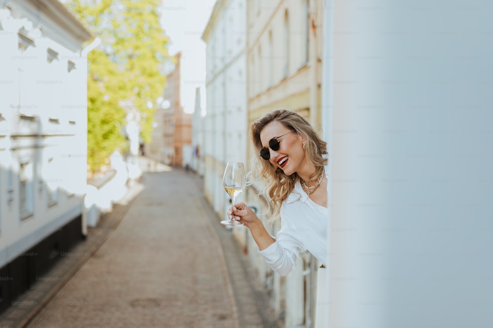 a woman holding a glass of wine in her hand