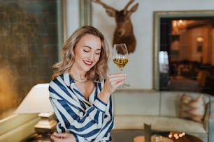 Una mujer sosteniendo una copa de vino en la mano