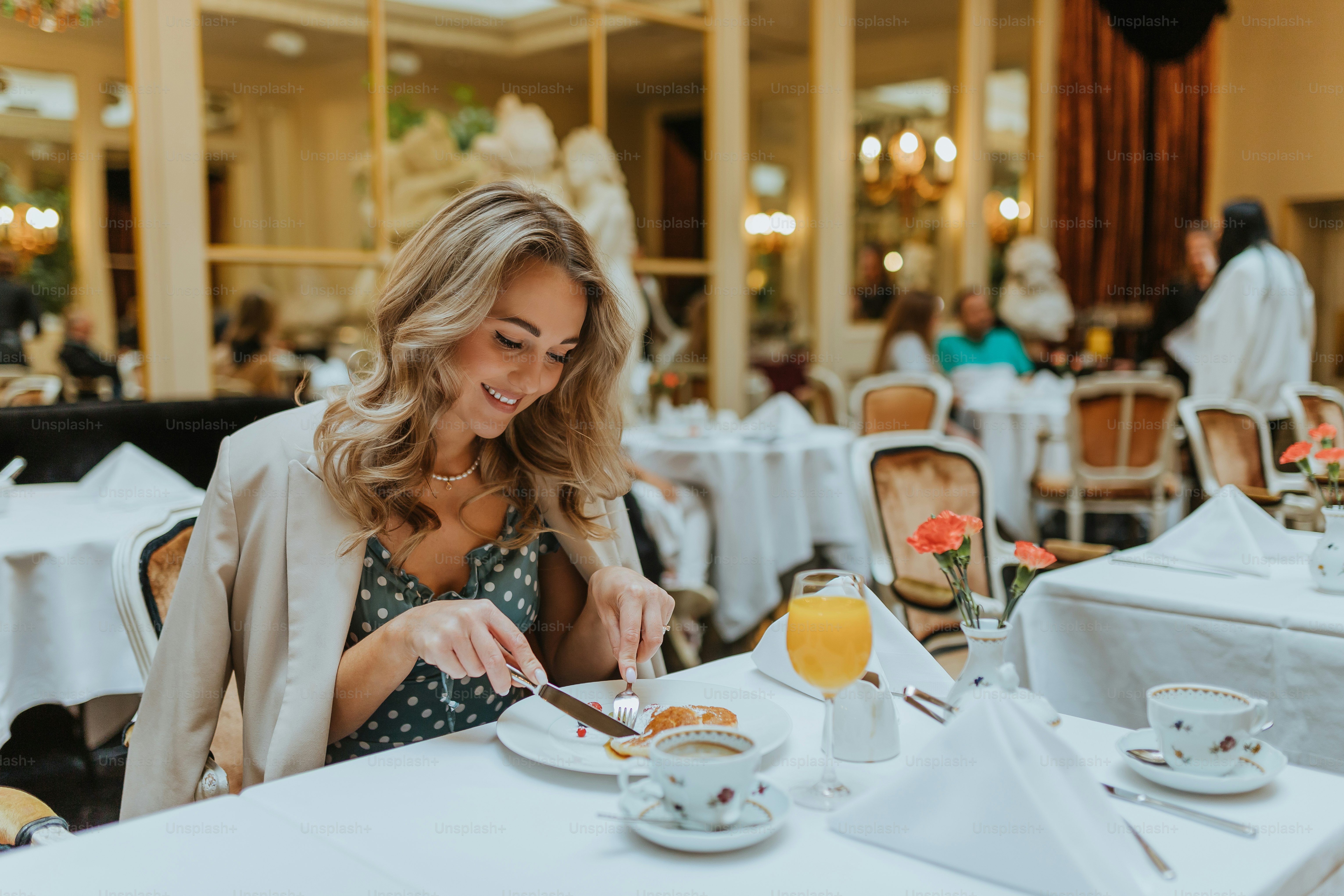 a woman sitting at a table with a plate of food