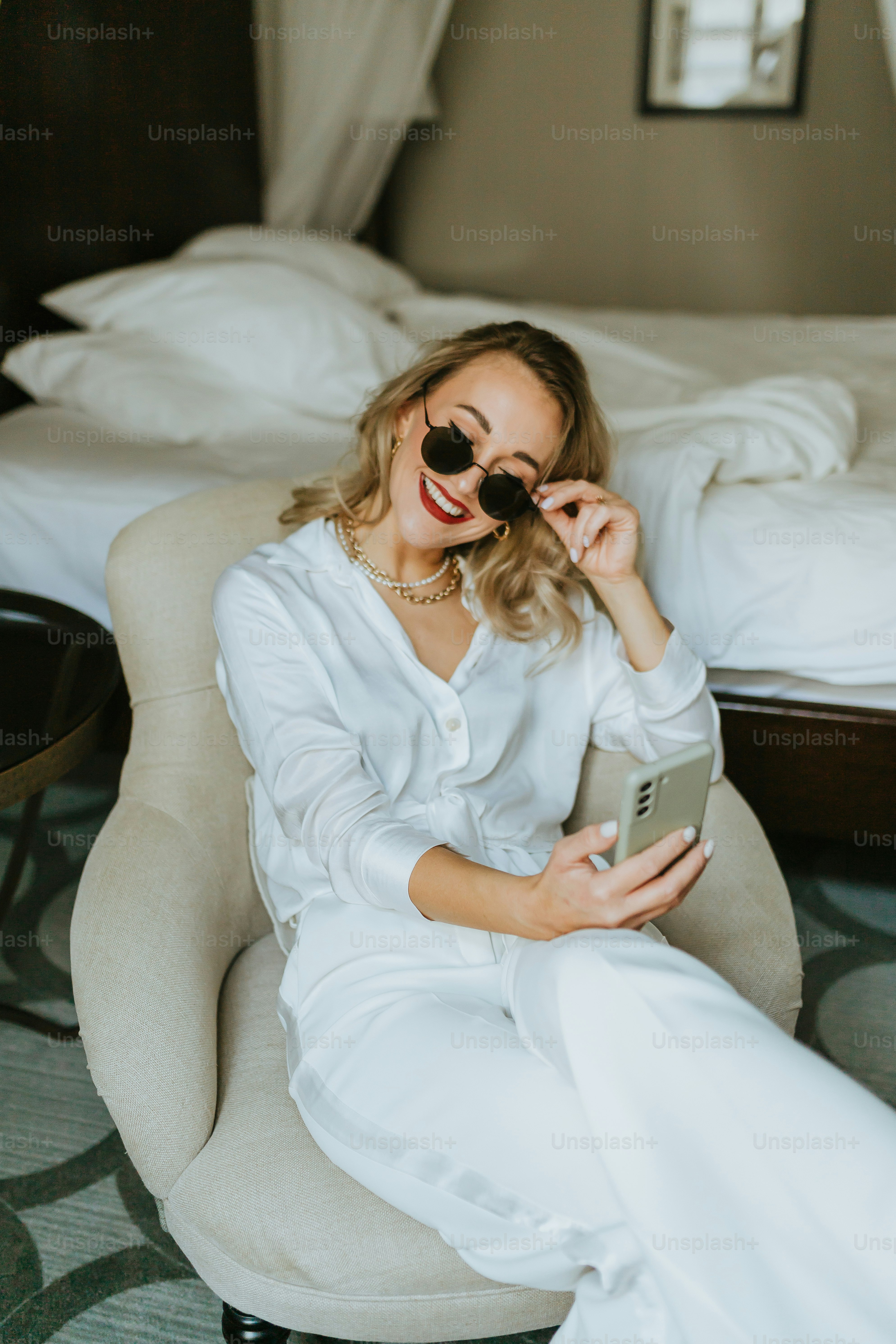 a woman sitting on a chair in a bedroom