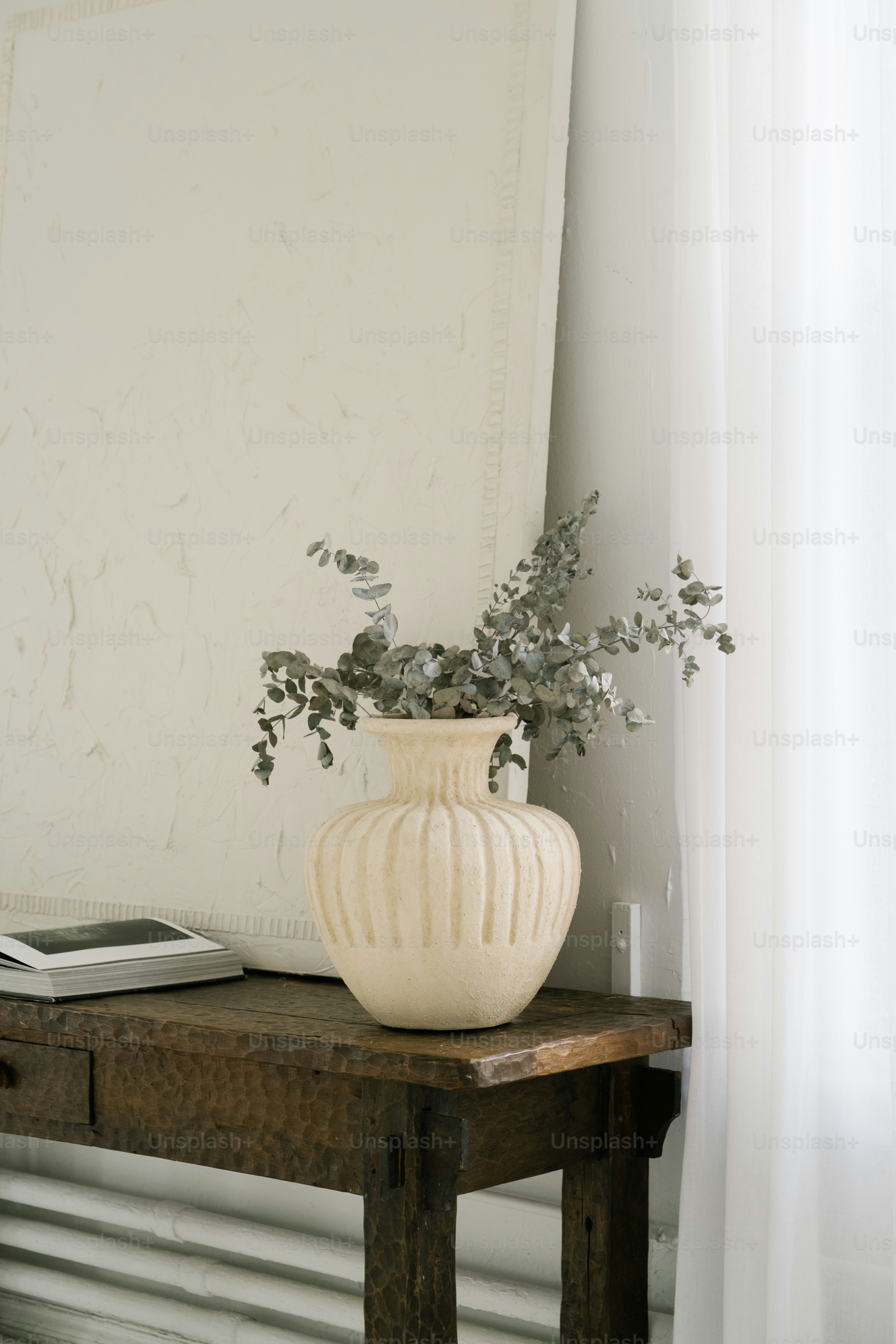 a white vase sitting on top of a wooden table