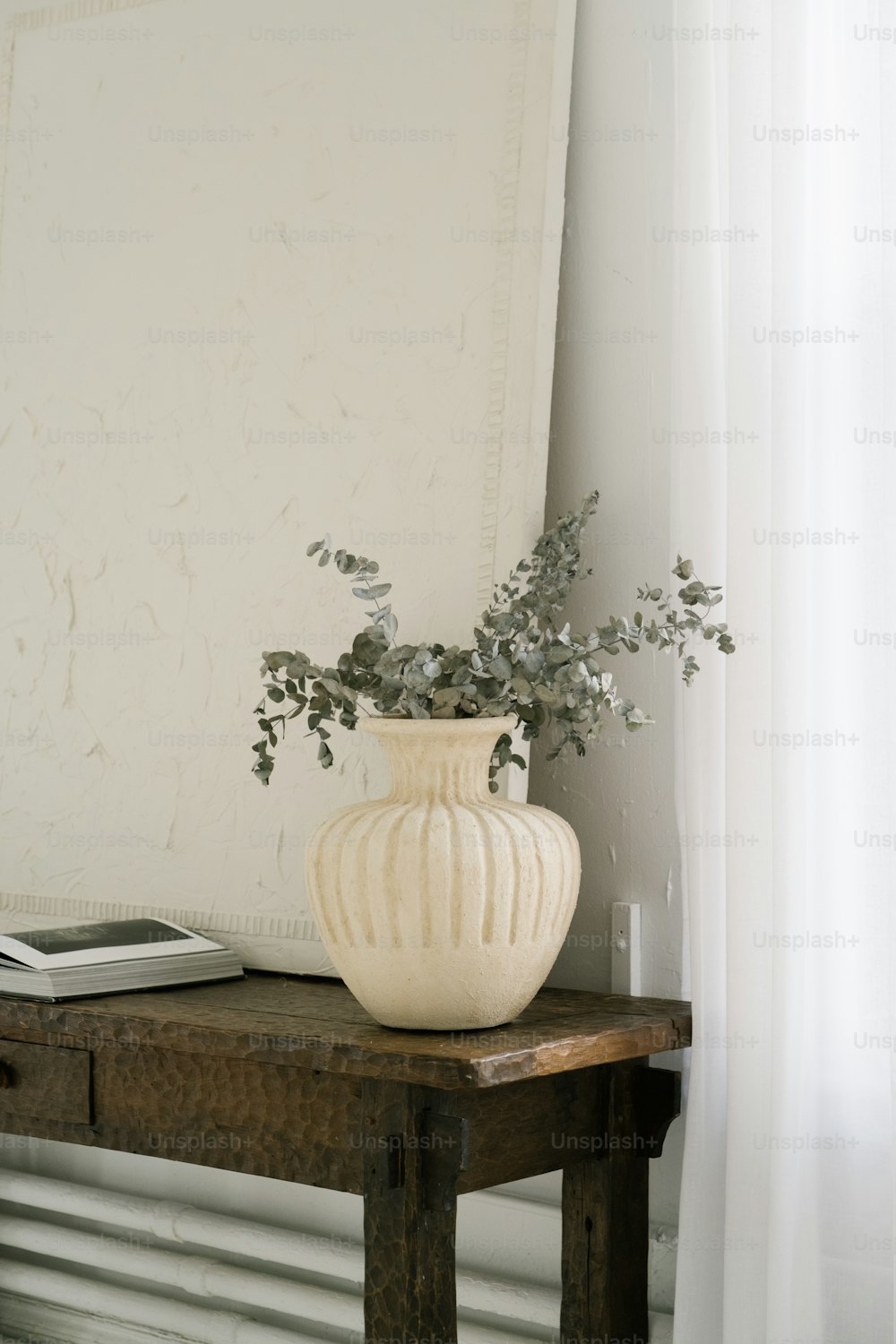un vaso bianco seduto sopra un tavolo di legno
