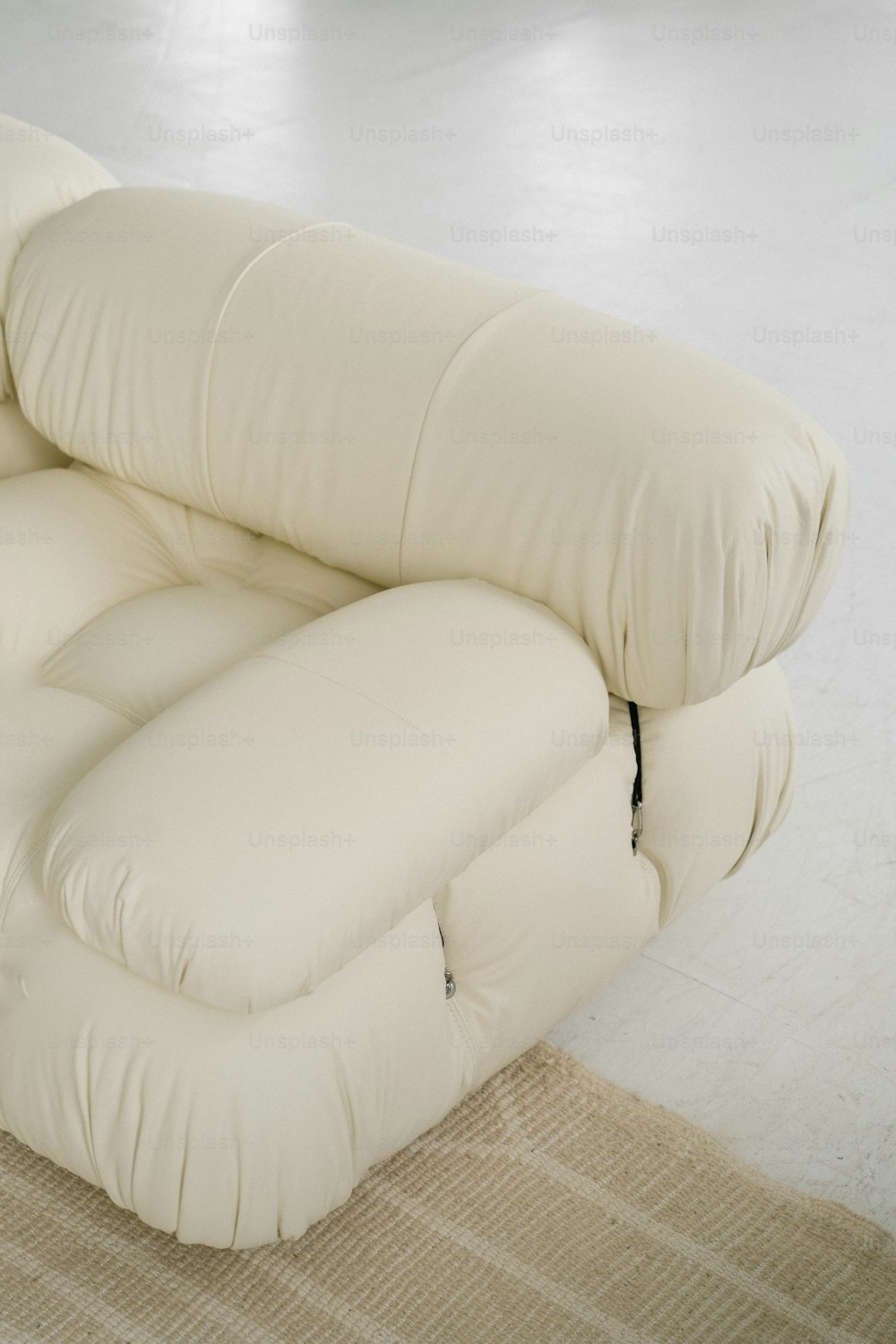 eine weiße Couch, die auf einem Teppich sitzt