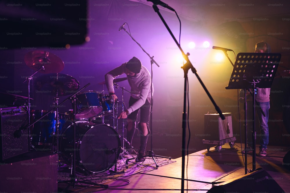 uma banda tocando em um palco com microfones