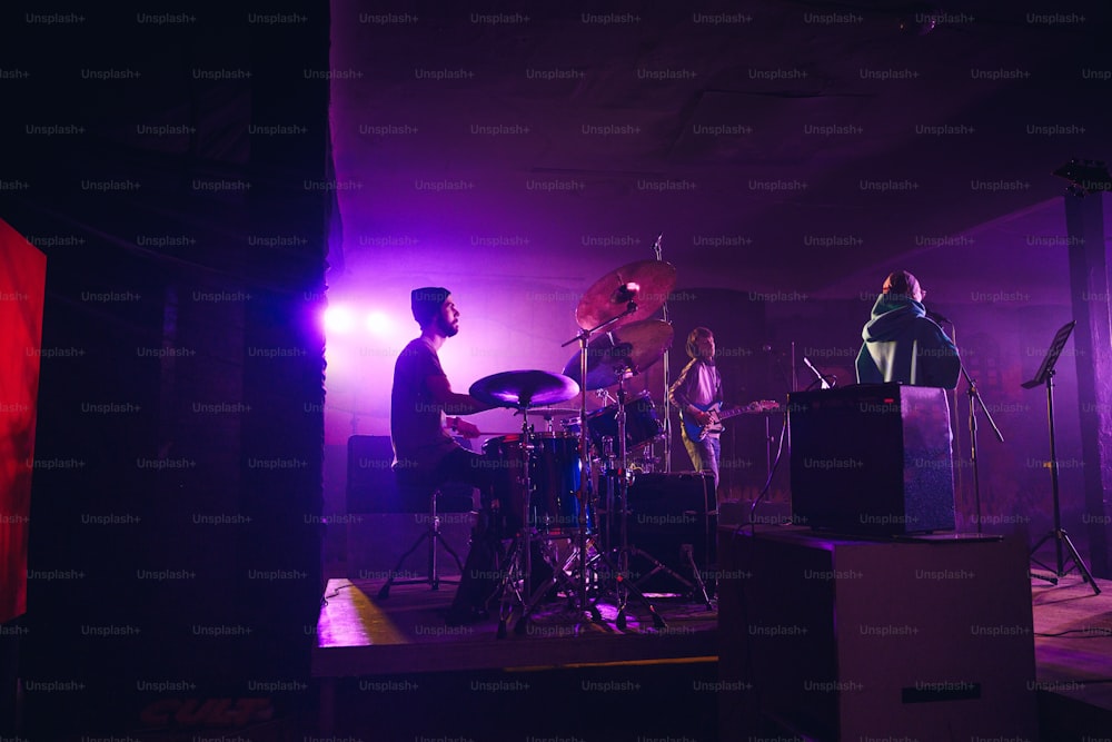 a band playing on stage in a dark room