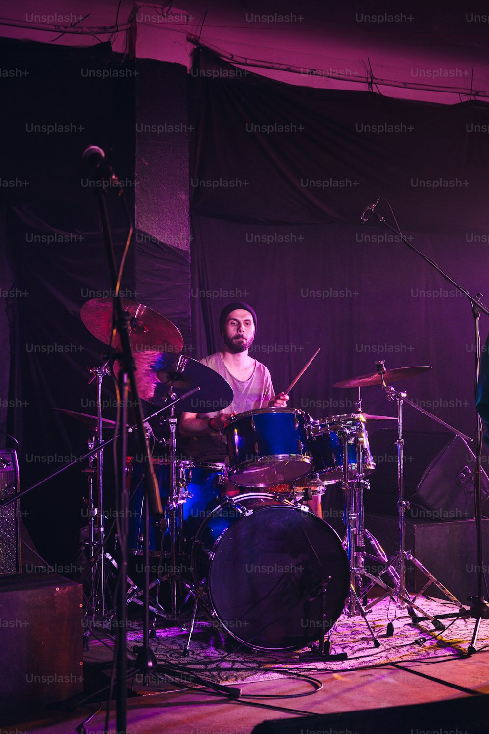 한 남자가 무대에서 드럼을 치고 있다
