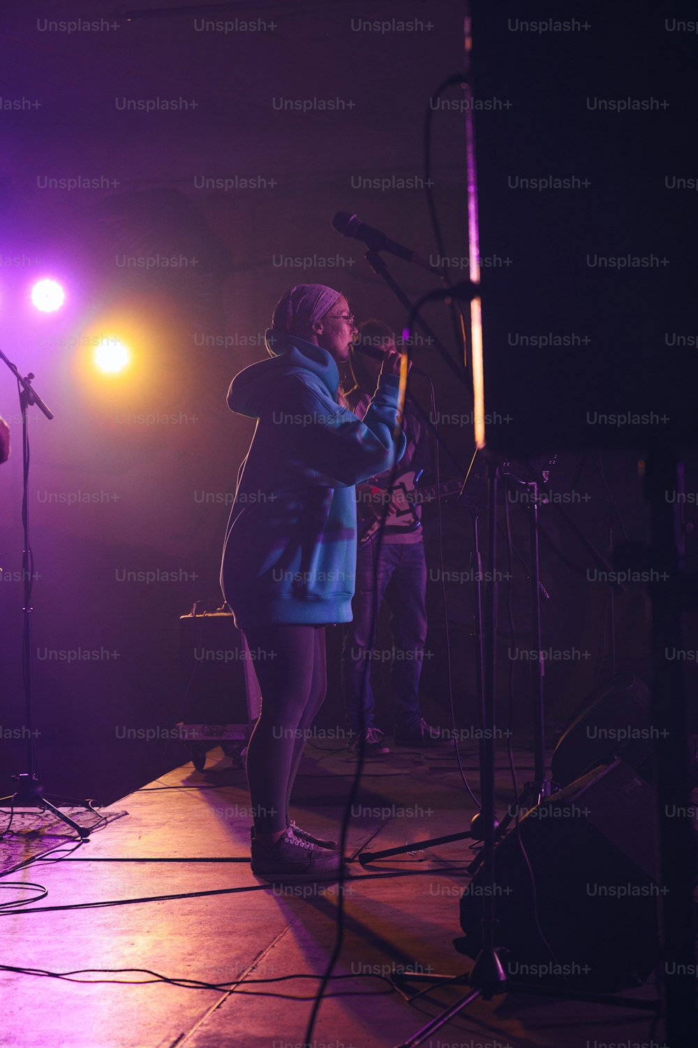 a woman standing on a stage singing into a microphone