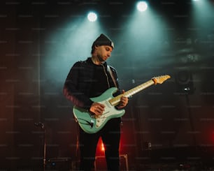 a man playing a guitar on a stage