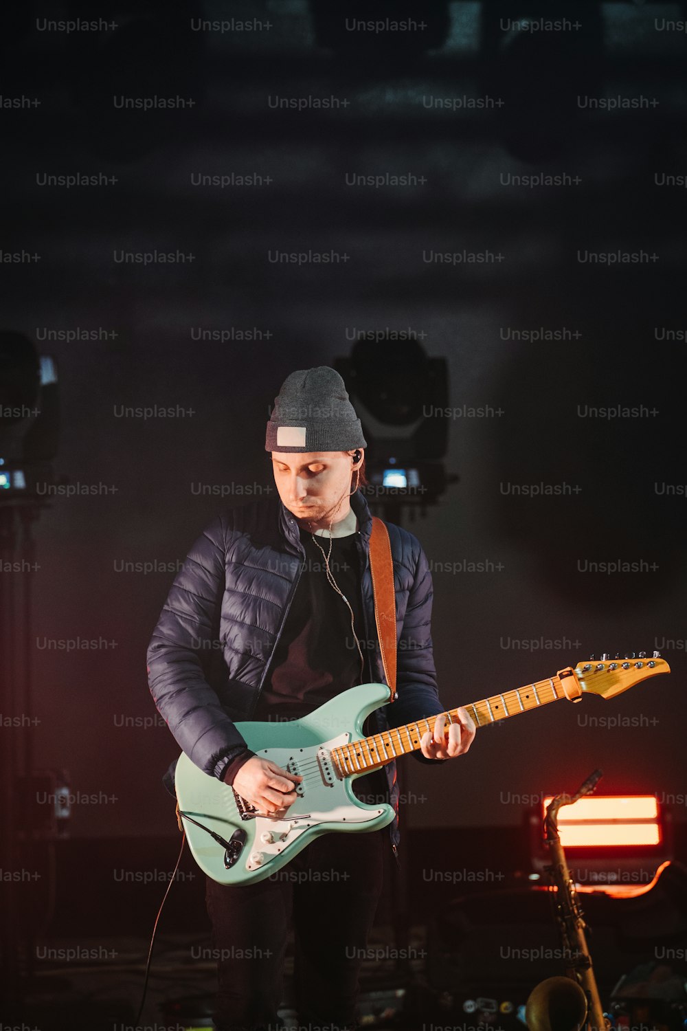 um homem tocando violão no palco em um concerto