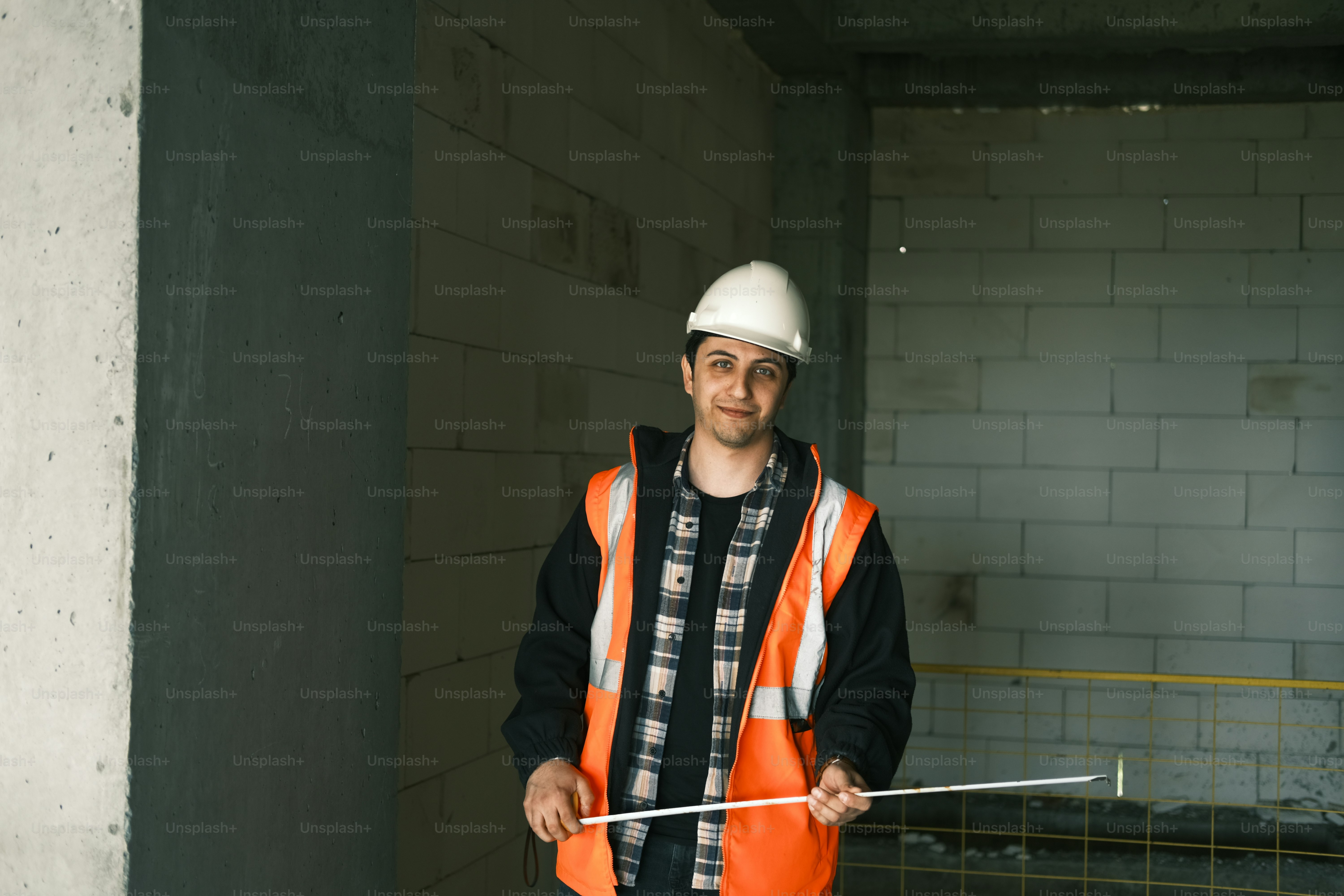 Ein Mann, der einen Schutzhelm trägt und einen Stock hält