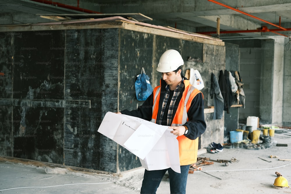 Ein Bauarbeiter hält ein Stück Papier in der Hand