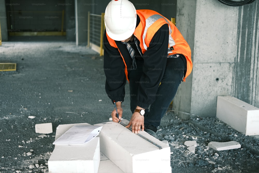 a man in a hard hat and safety vest working on a box