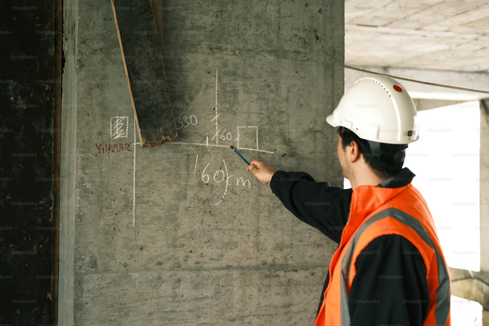 콘크리트 벽에 글을 쓰는 건설 노동자