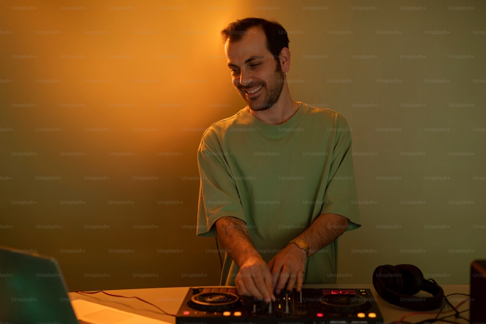 a man that is sitting at a table with a dj's mixer