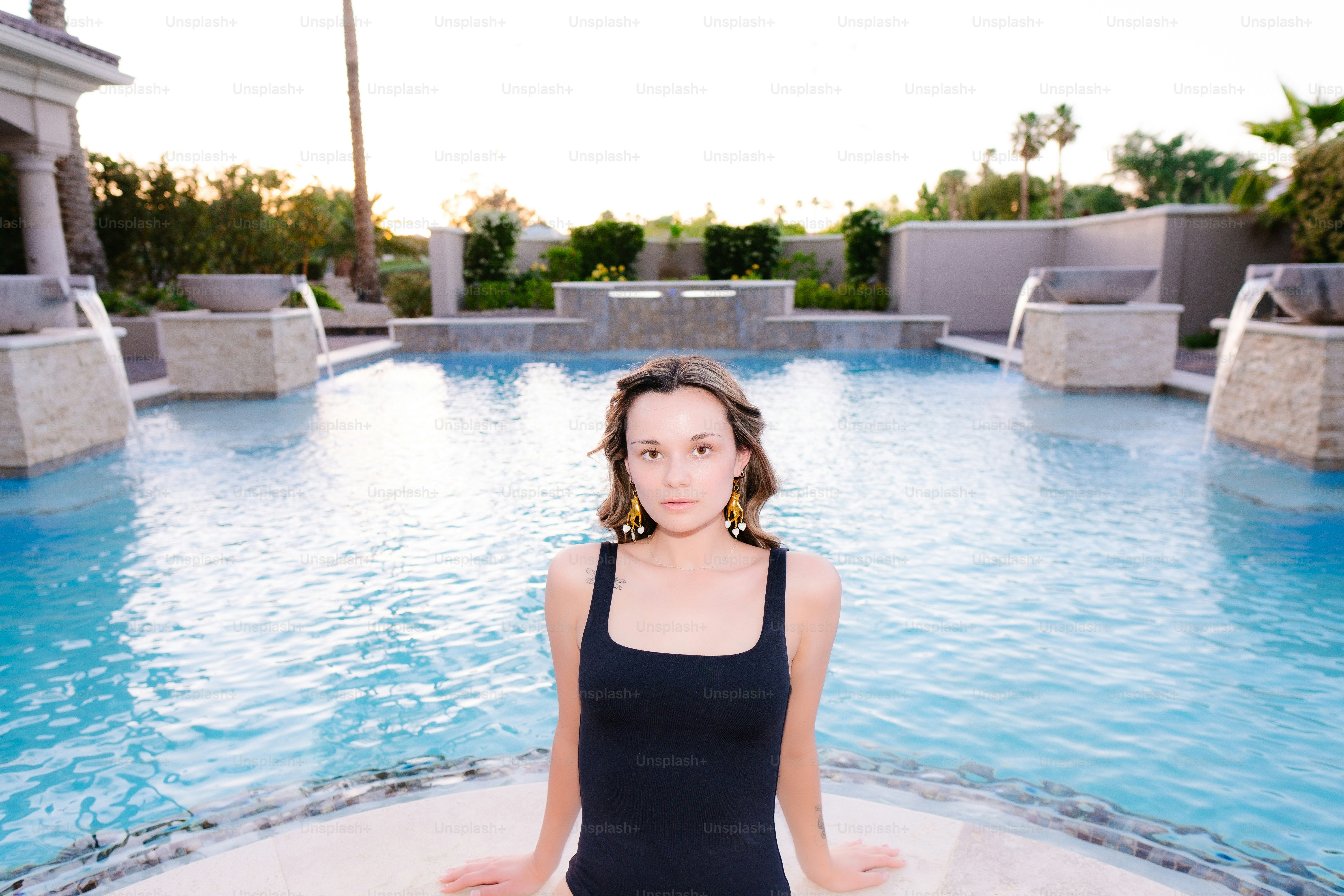 a woman in a black tank top sitting in a pool