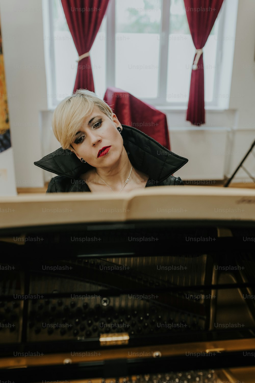 a woman sitting at a piano looking at the camera