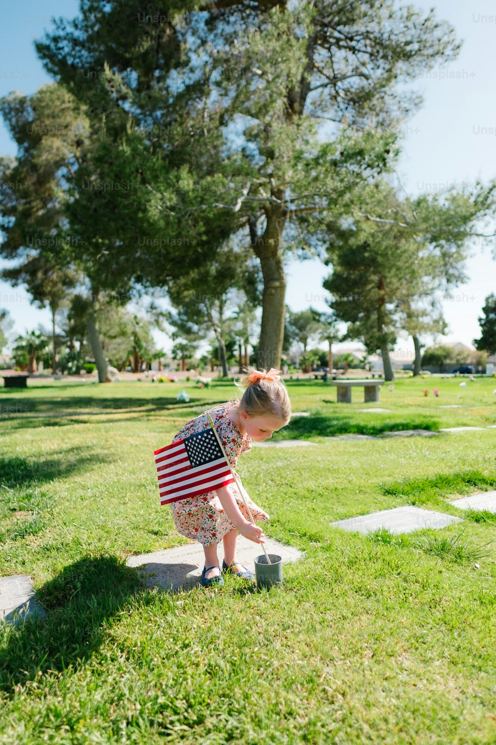 a little girl standing on top of a grass covered field