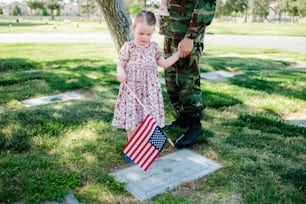 アメリカの国旗を持つ兵士の隣に立っている少女