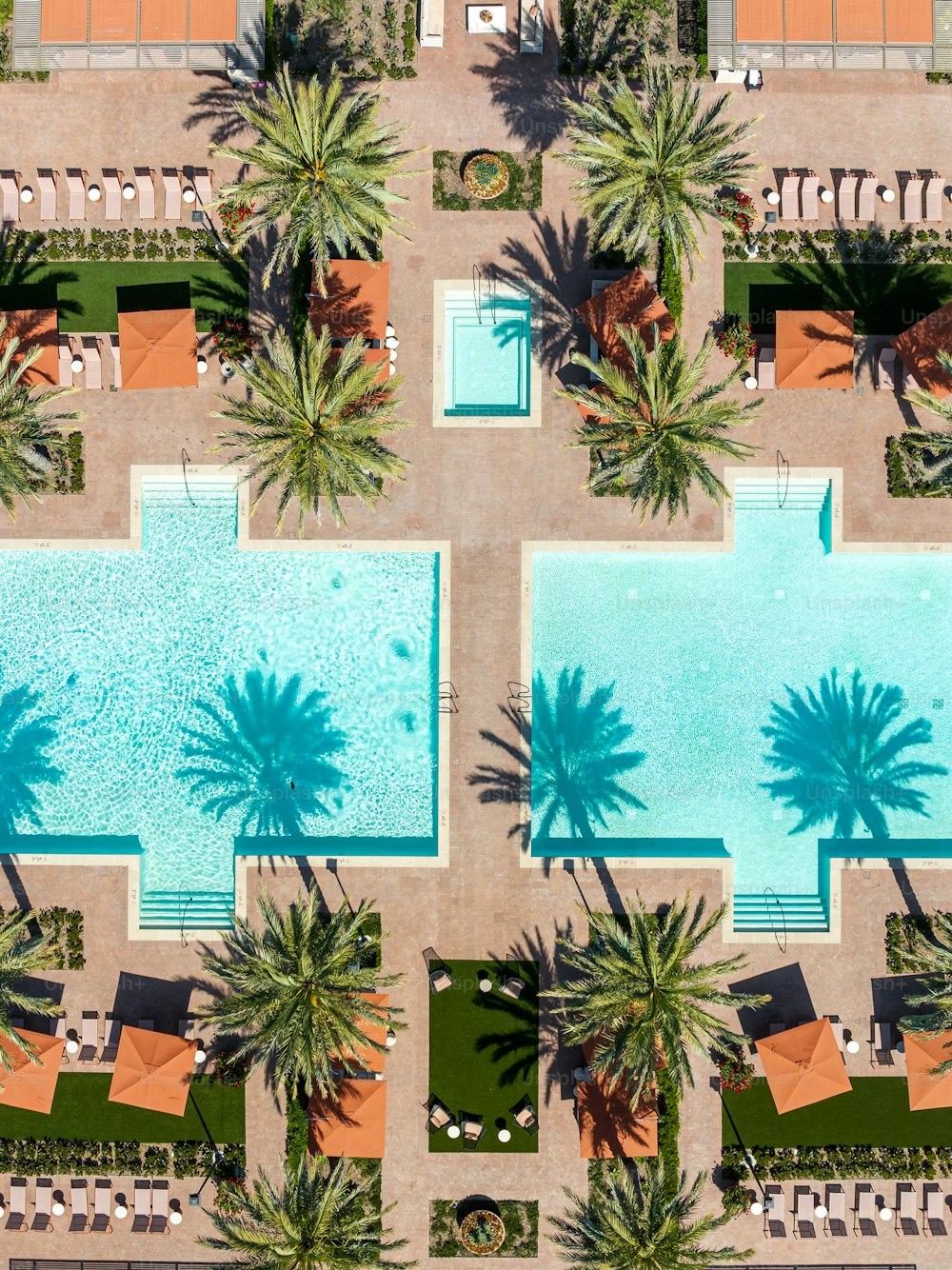 an aerial view of a swimming pool surrounded by palm trees