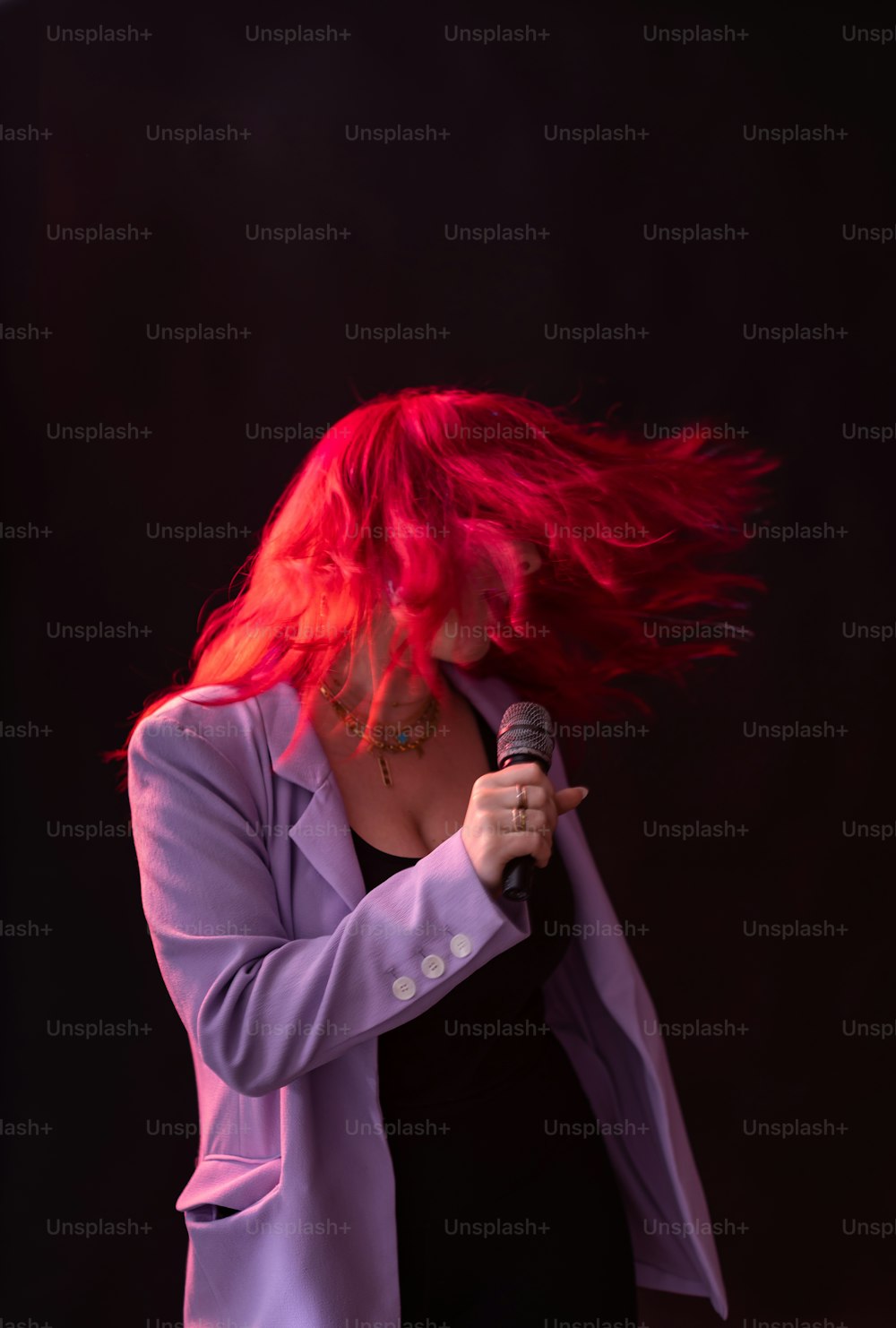 a woman with red hair holding a microphone