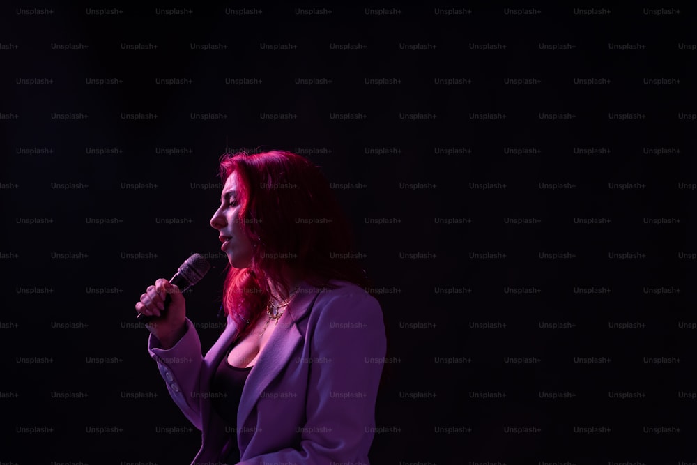 a woman with red hair is holding a microphone