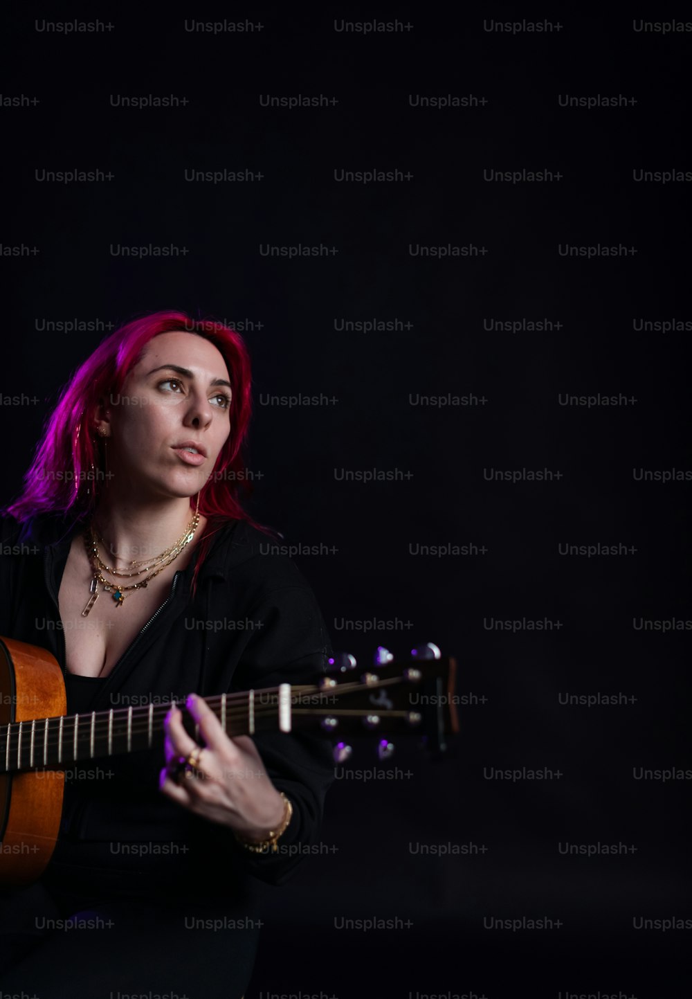 Eine Frau mit roten Haaren, die Gitarre spielt