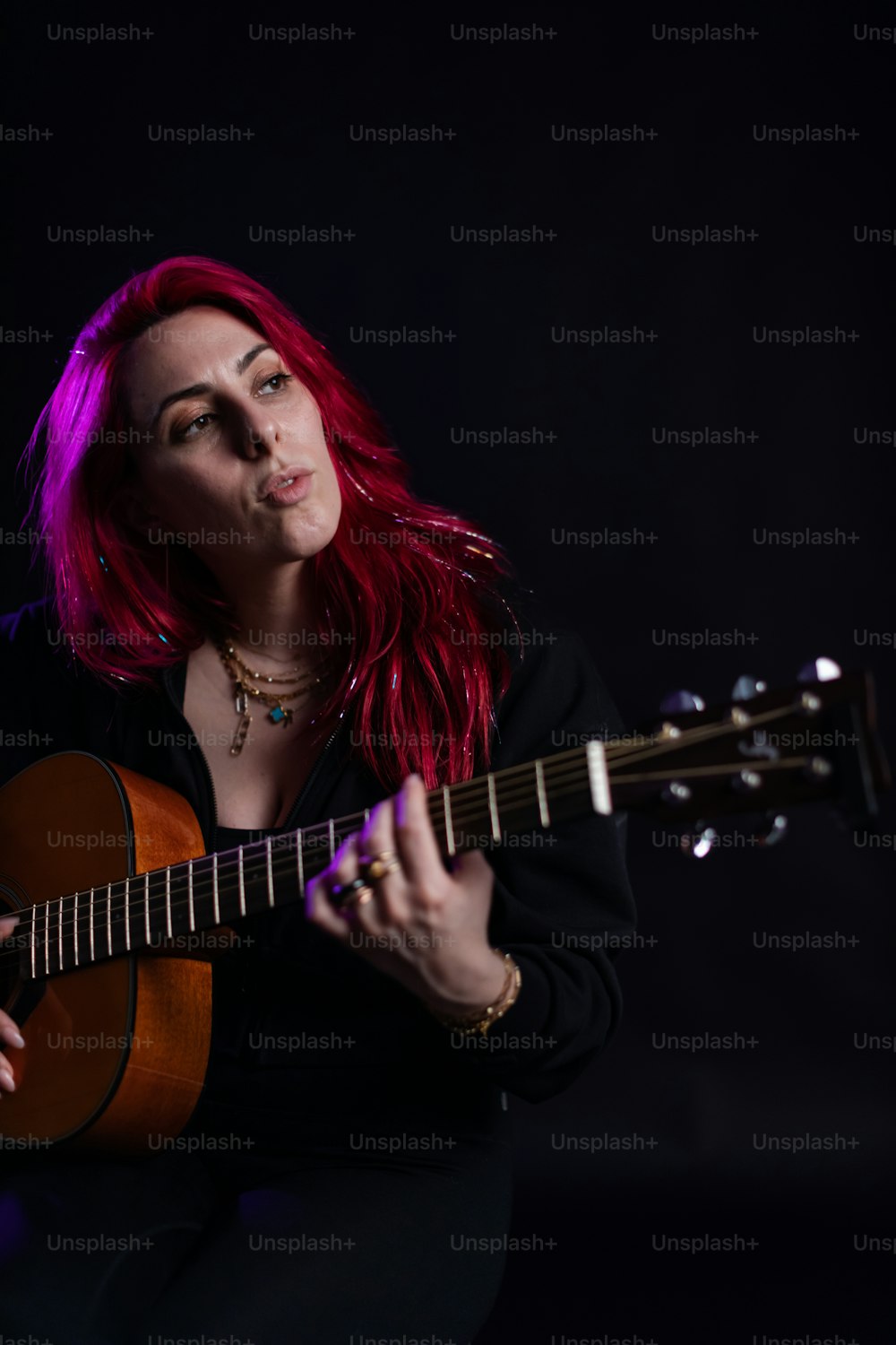 uma mulher com cabelo ruivo tocando um violão