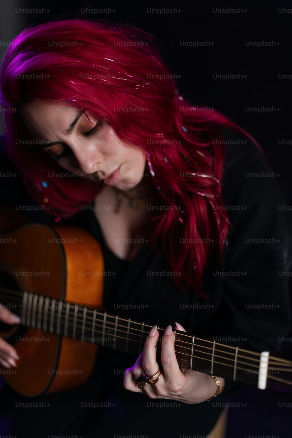 a woman with red hair playing a guitar