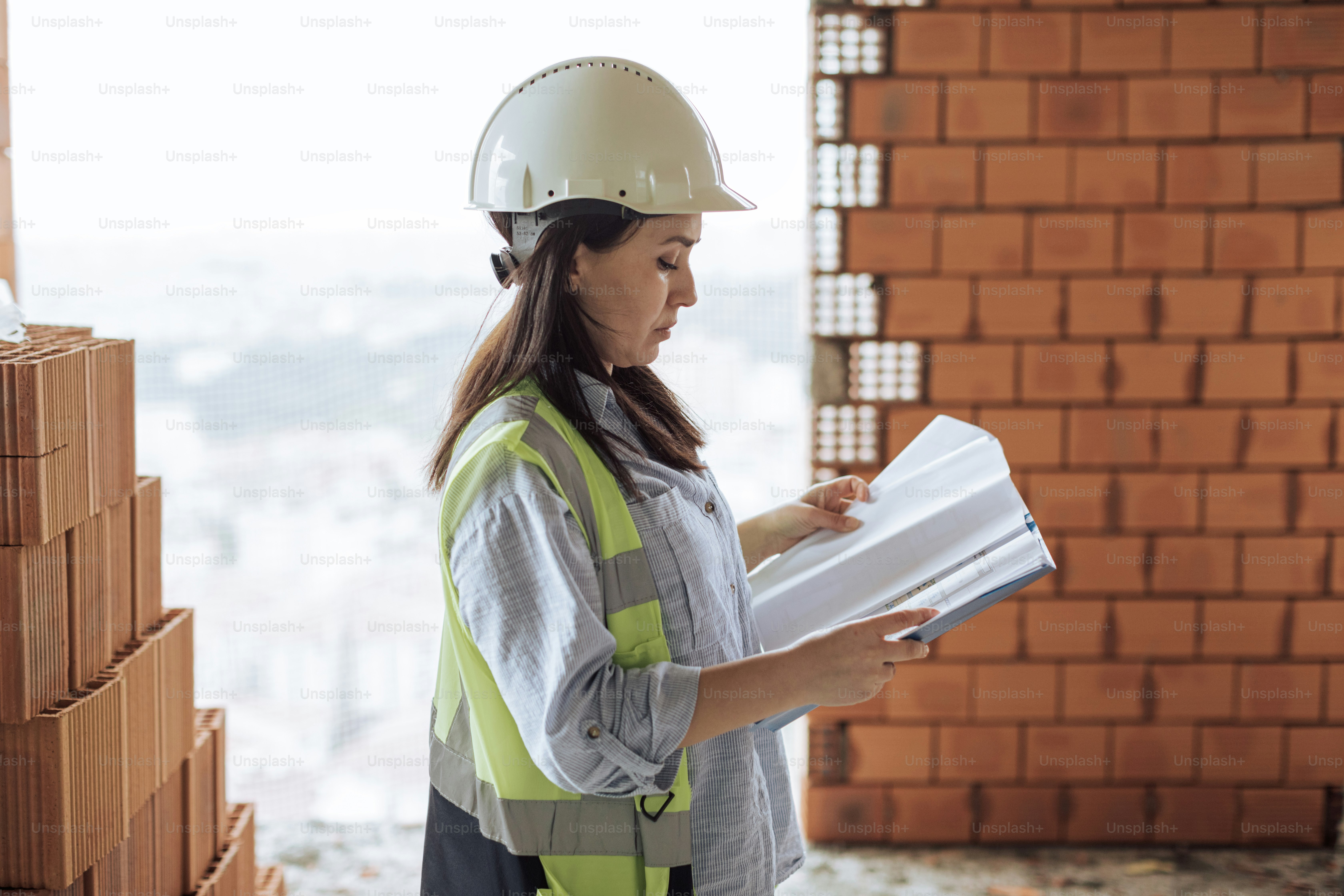 a woman in a hard hat holding a piece of paper