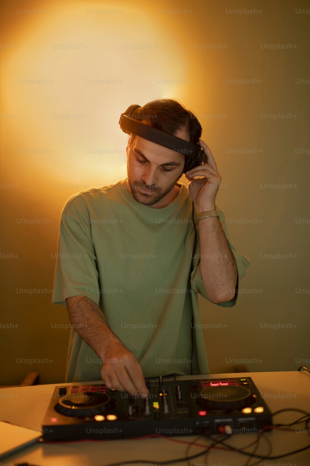 a man in a green shirt is using a dj's turntable