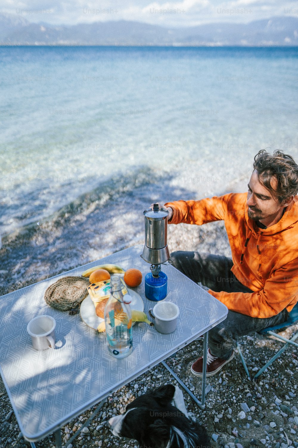 a man sitting at a table near the ocean