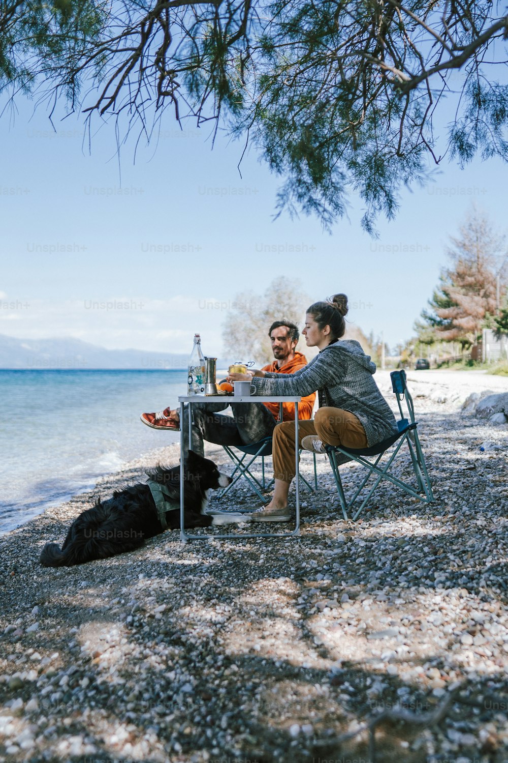 um homem e uma mulher sentados em uma mesa na praia
