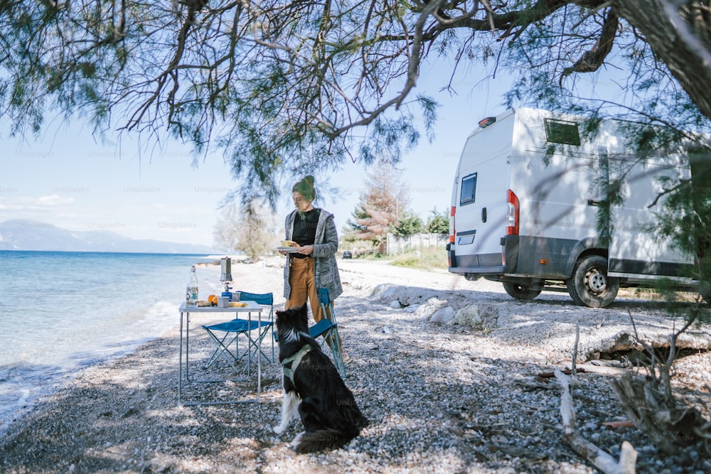 Ein Mann, der neben einem Hund am Strand steht