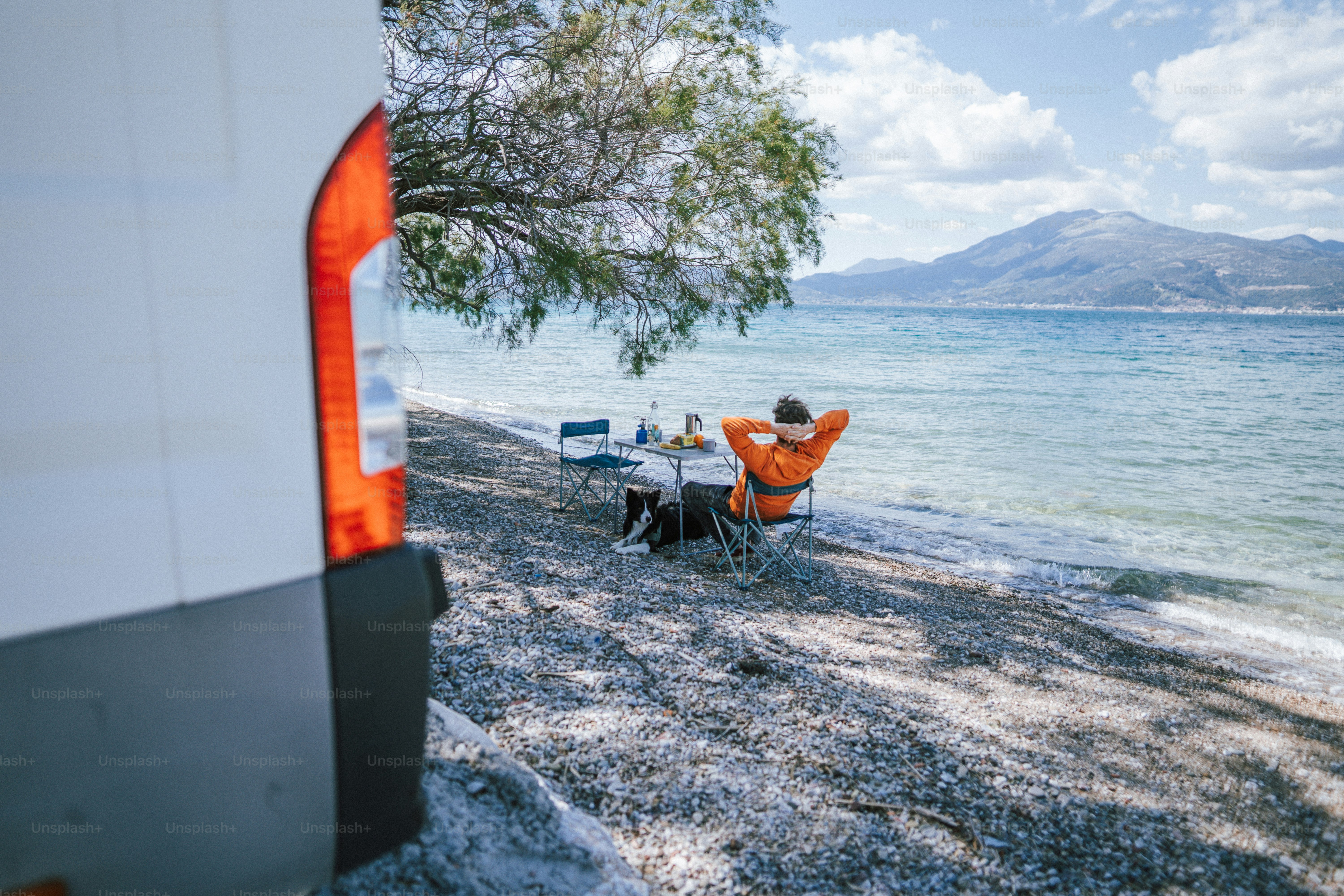 a man sitting at a table next to the ocean