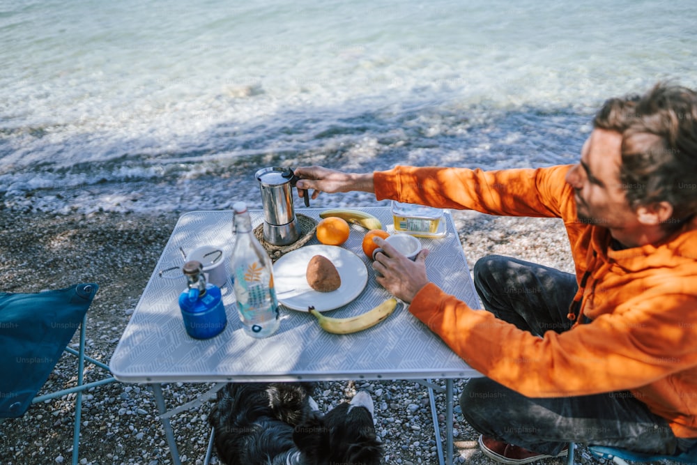 a man sitting at a table with a plate of food