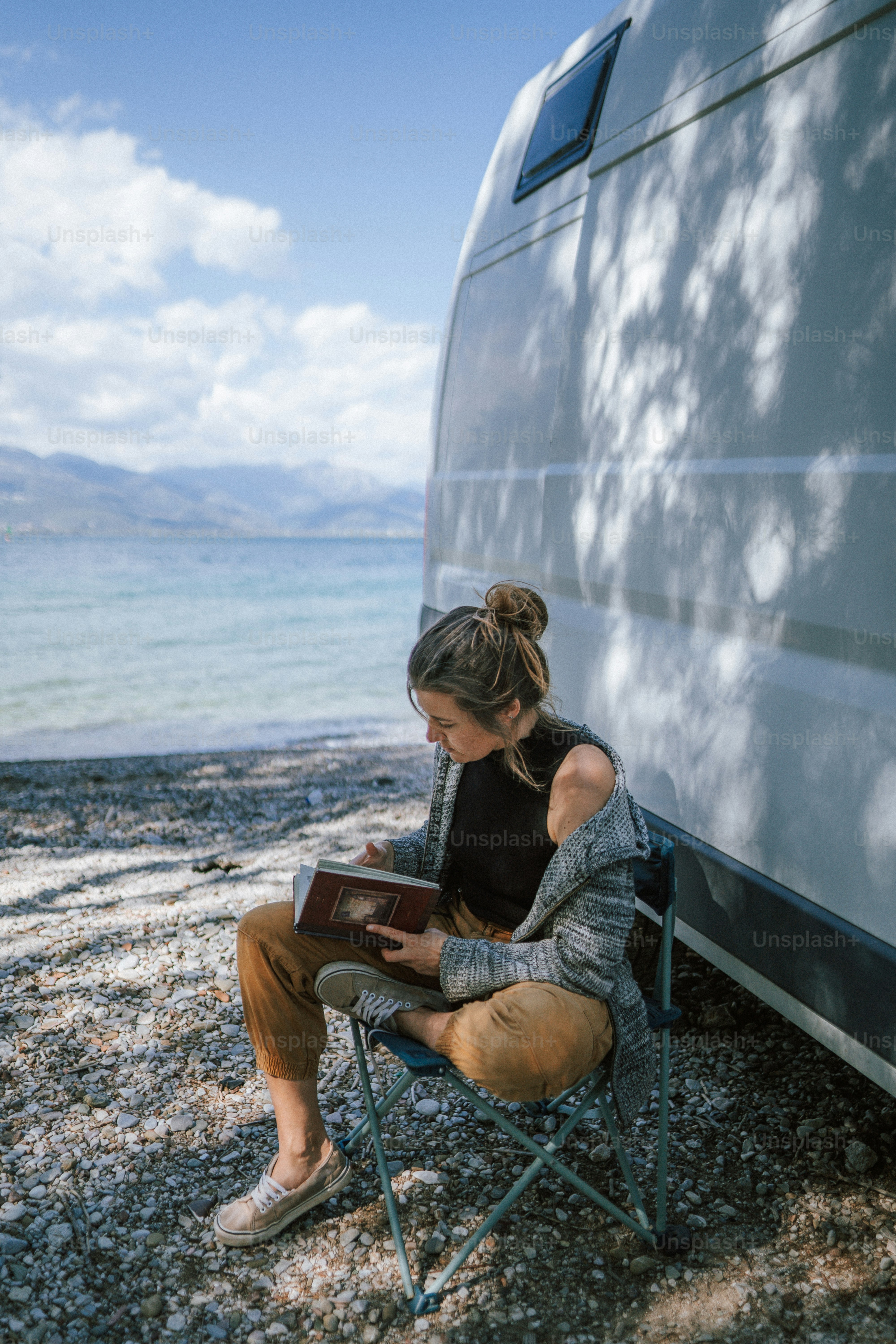 A woman standing next to a van on a beach photo – Camping Image on Unsplash