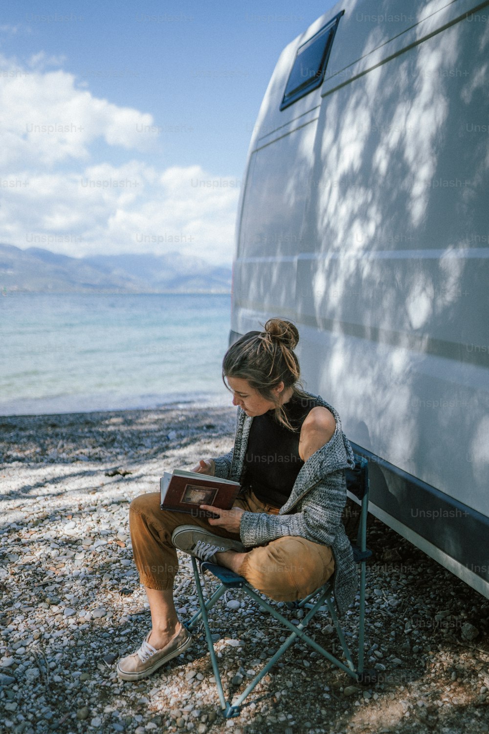 a woman sitting in a chair next to a motor home