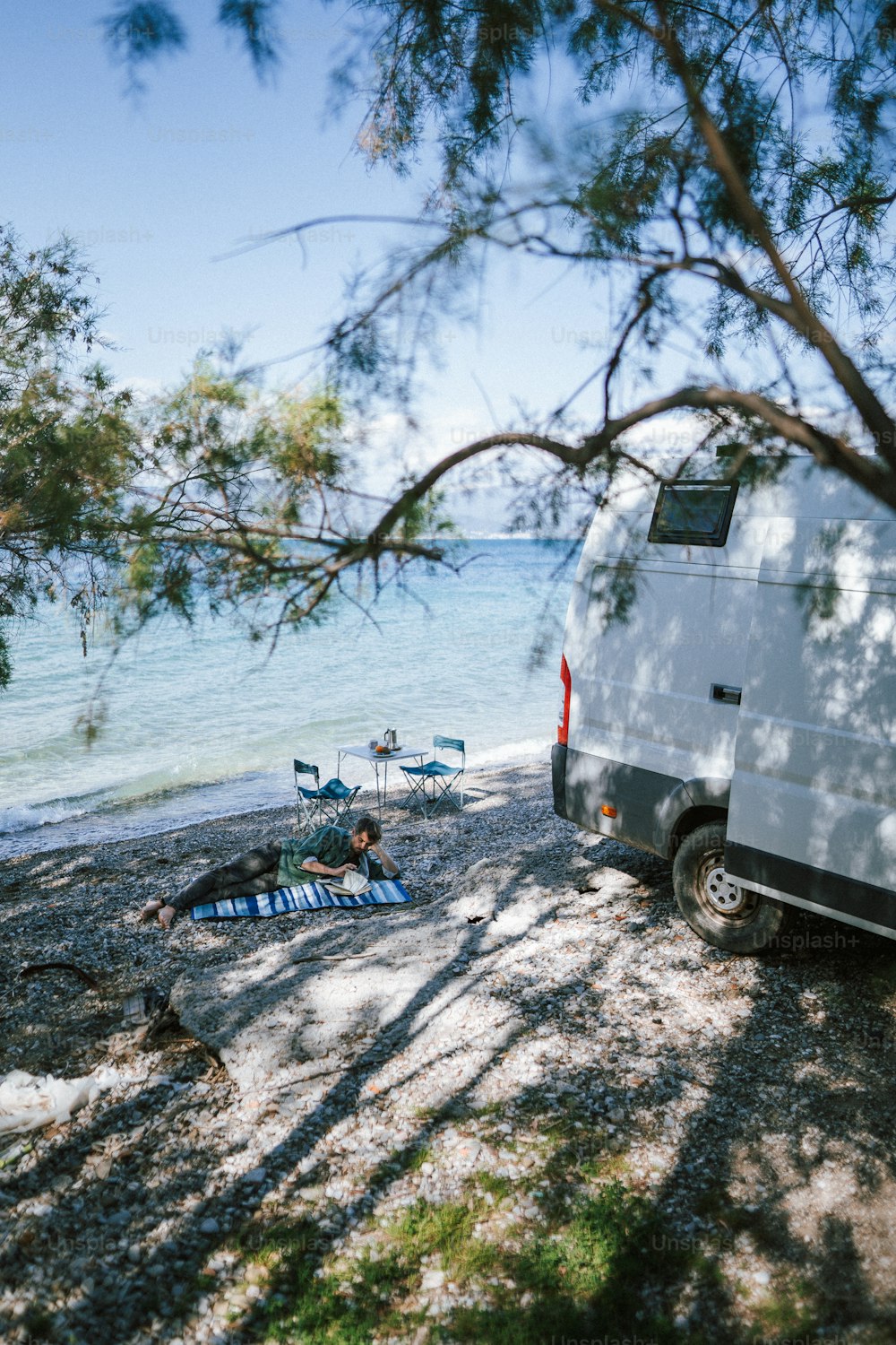 Ein Van, der an einem Strand neben dem Meer geparkt ist