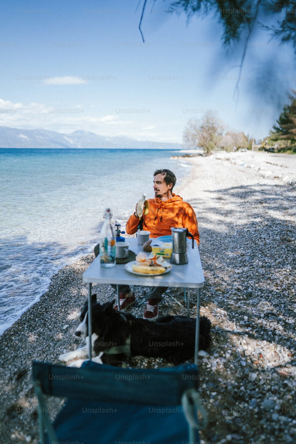 um homem sentado em uma mesa na praia