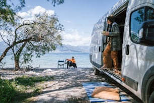 a man and his dog are sitting in the back of a van