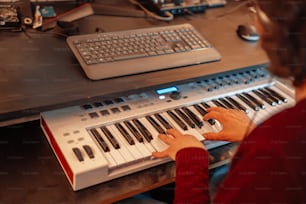 uma pessoa tocando um teclado em uma mesa