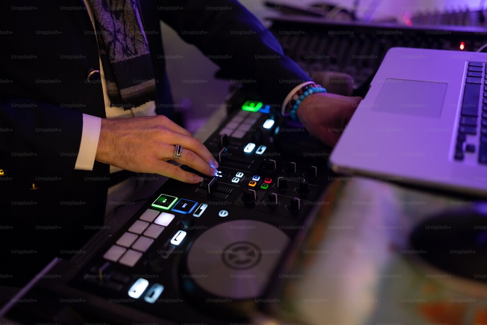 노트북 앞 턴테이블에서 음악을 믹싱하는 DJ