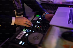 Un DJ mezclando música en un tocadiscos frente a una computadora portátil