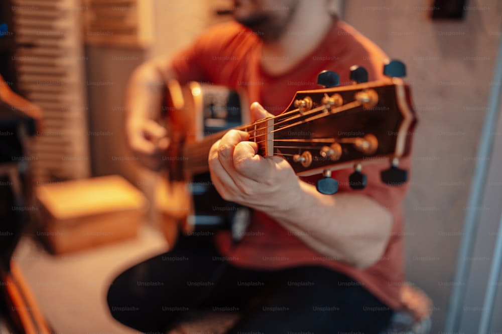 a man playing a guitar in a room