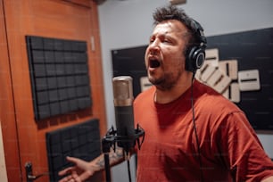a man singing into a microphone in a recording studio