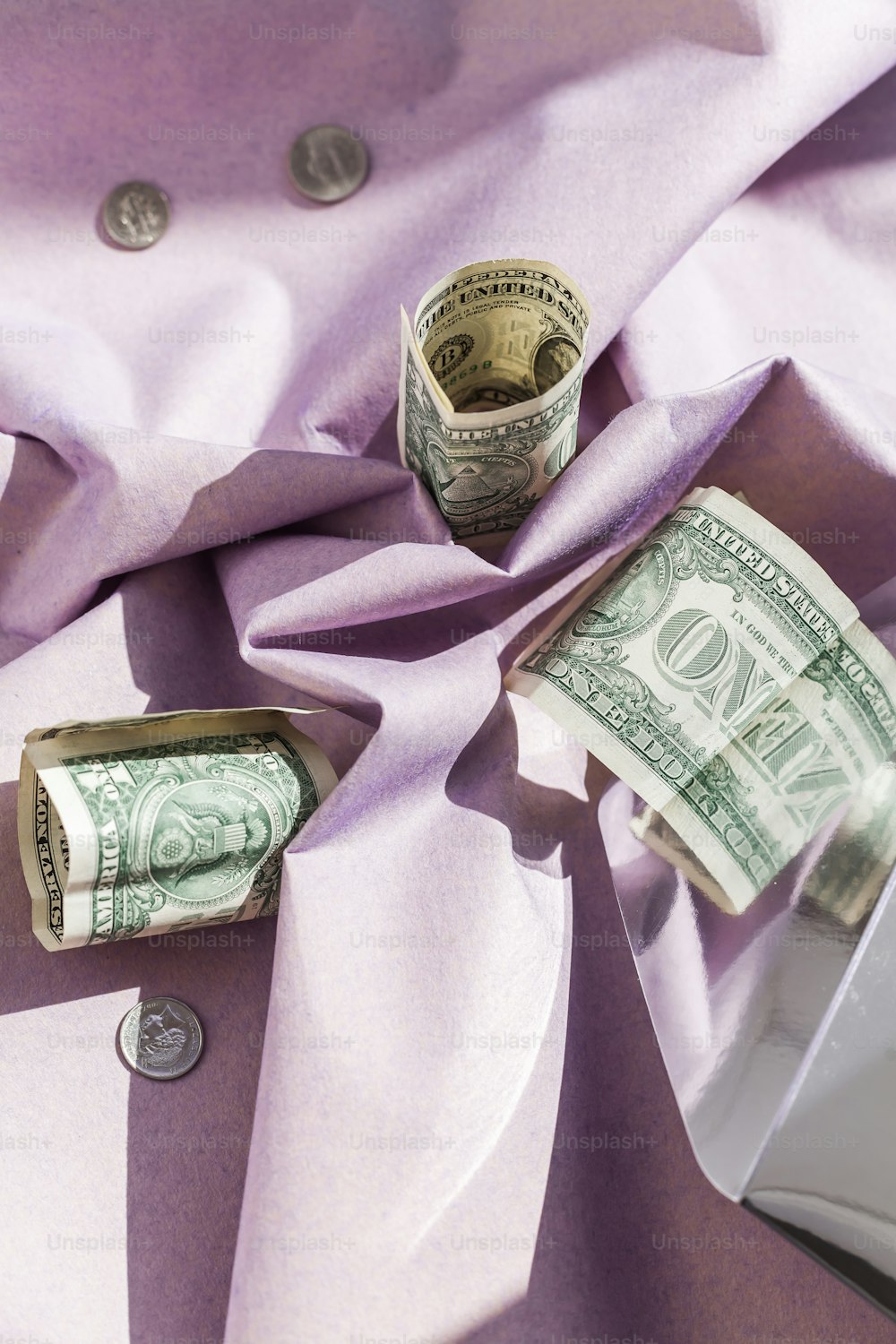 お金のロールが紫色の布の上に置かれています