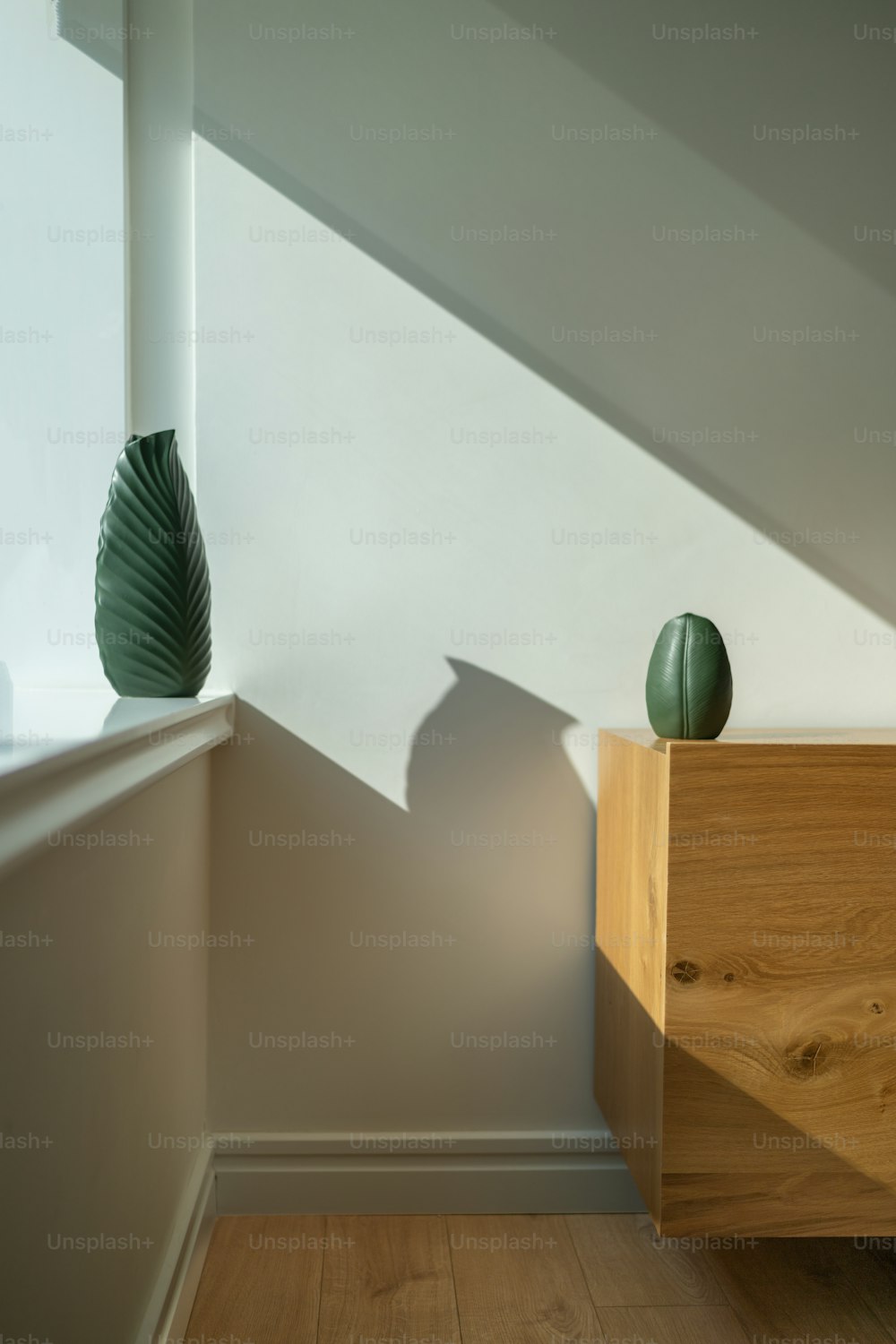 two green vases sitting on top of a wooden dresser