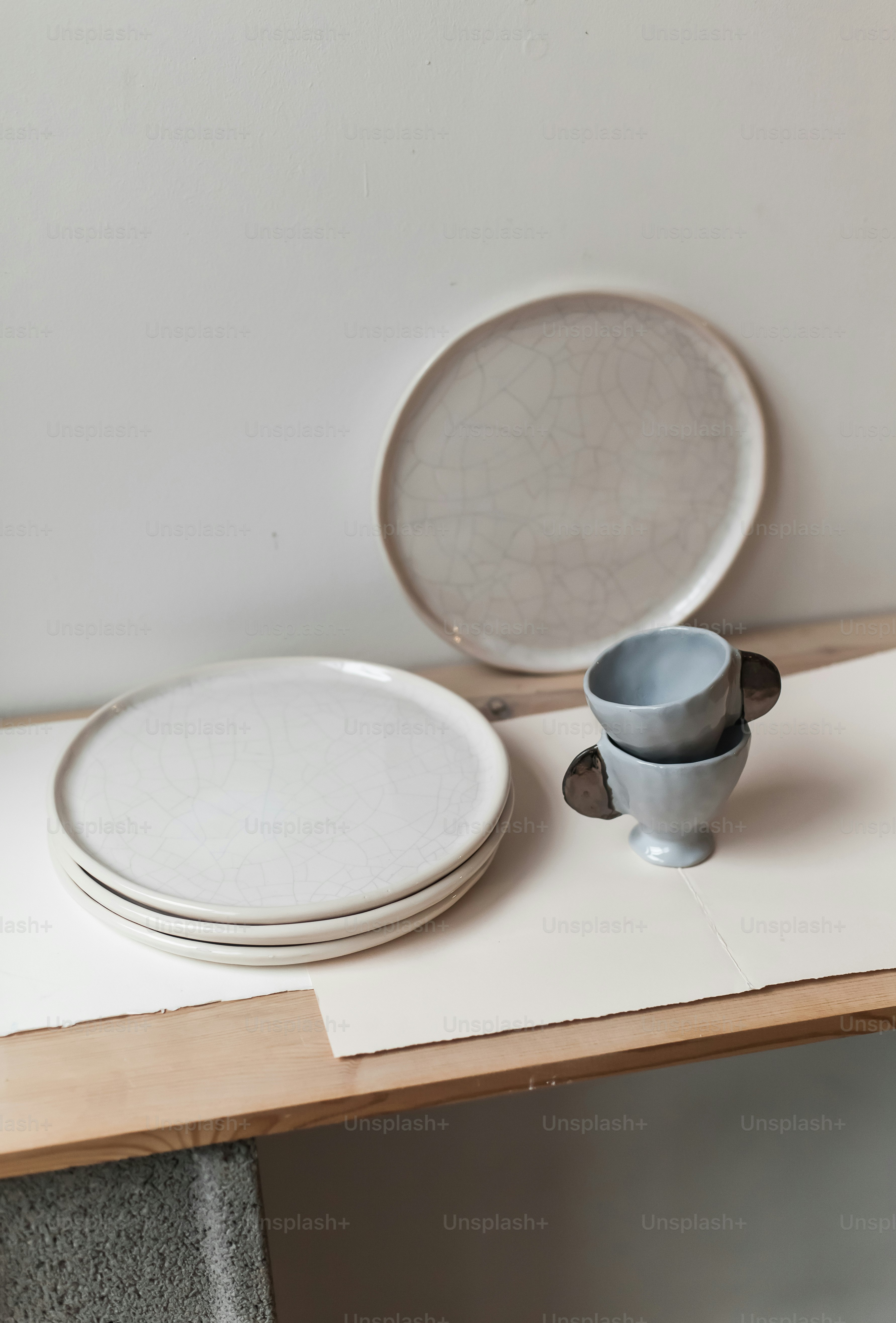 A table topped with plates and bowls on top of a wooden table photo ...