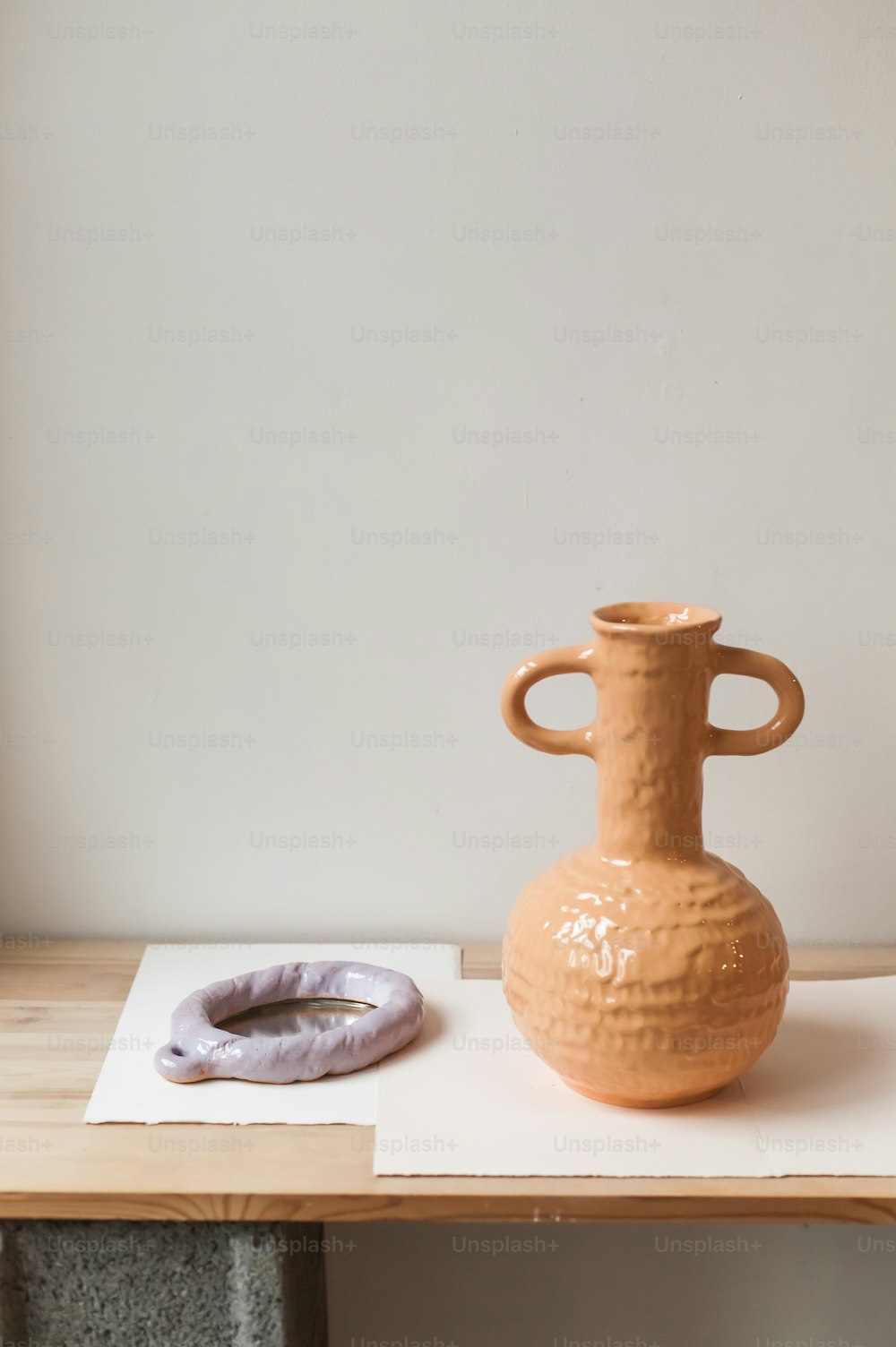a brown vase sitting on top of a wooden table